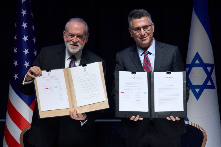 ap_6a451b0115083-1782913793 Israeli Foreign Minister Gideon Sa'ar (right) and U.S. Ambassador to Israel Mike Huckabee present the land‑allocation agreement for the permanent U.S. Embassy in Jerusalem to the audience during a ceremony on Wednesday, July 1, 2026. (AP Photo/Ohad Zwigenberg)