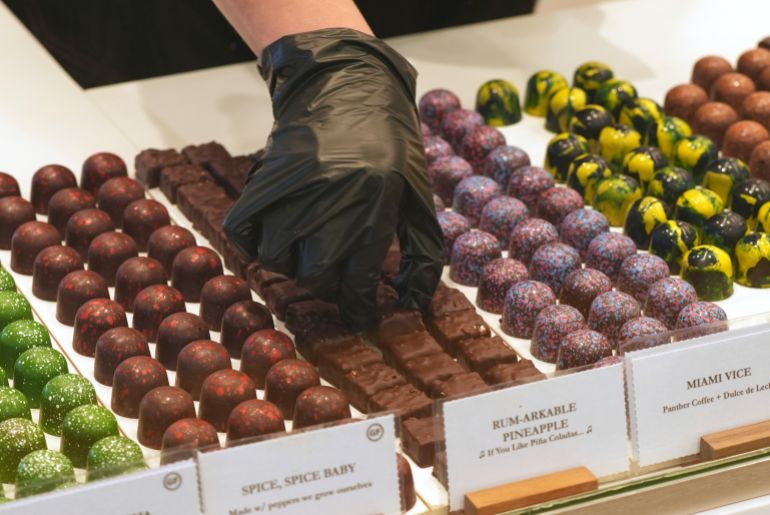 ap_6a4cda3e6e2a8-1783421502 An employee at Exquisito Chocolates selects bon bon's for a client, Wednesday, Aug. 13, 2025, in the Little Havana neighborhood of Miami. (AP Photo/Marta Lavandier)