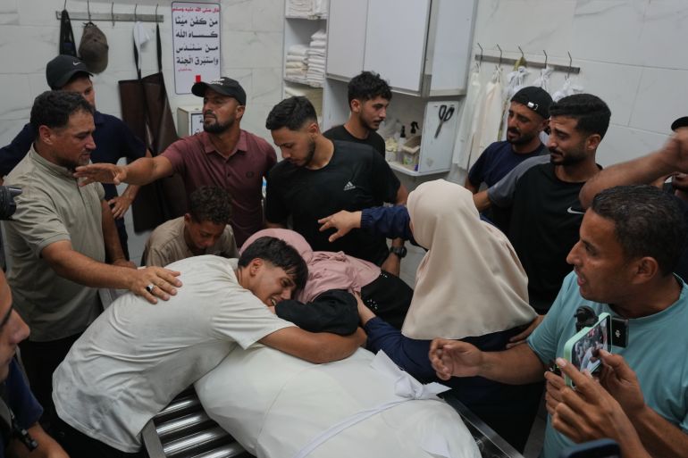 ap_6a4d0554be660-1783432532 Friends and relatives mourn over the body of Omran Abu Jarad, 48, who was killed in an Israeli military strike, during his funeral at Al-Shifa Hospital in Gaza City, Tuesday, July 7, 2026. (AP Photo/Abdel Kareem Hana)