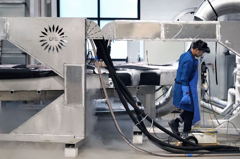 ap_6a51f0d74cbc2-1783754967 A magnet test engineer checks fluid levels in a testing device at Commonwealth Fusion Systems, in Devens, Mass., Wednesday, Oct. 11, 2023. Commonwealth is trying to create fusion inside what's called a tokamak. Nuclear fusion, which would be a new source of carbon-free energy, melds two hydrogen atoms together to produce a helium atom and a lot of energy. (AP Photo/Steven Senne)