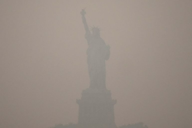ap_6a59b185e8a5d-1784263045 The Statue of Liberty stands during sunset as smoke from wildfires blankets the sky, Thursday, July 16, 2026, in the Brooklyn borough of New York. (AP Photo/Yuki Iwamura)