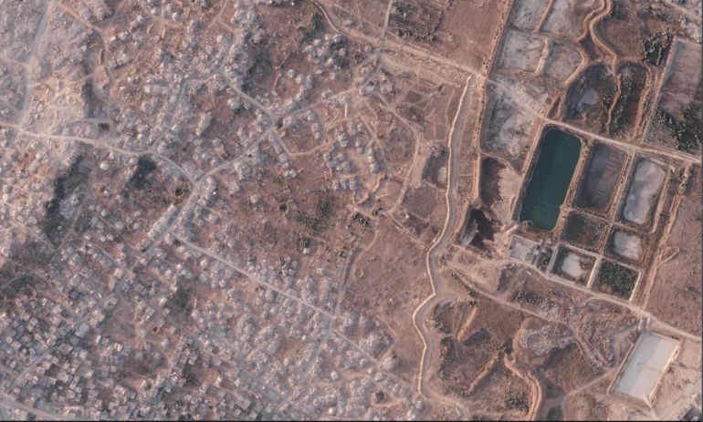 This satellite image from Planet Labs PBC shows a section of an earthen barrier being built by the Israeli military in the northern Gaza Strip, July 8, 2026. To the left is the demolished town of Beit Lahia, and at right a defunct sewage treatment plant. (Planet Labs PBC via AP)