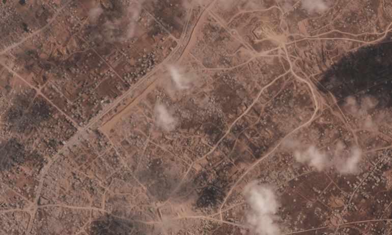 A satellite image from Planet Labs PBC shows a section of an earthen barrier being built by the Israeli military, seen starting at top center of image and moving down at an angle to the left, near the city of Khan Younis in the southern Gaza Strip, July 7, 2026. Two Israeli military bases are visible in the demolished town of Bani Suheila. (Planet Labs PBC via AP)