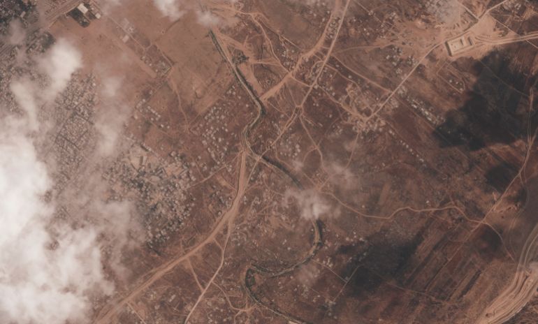 A satellite image from Planet Labs PBC shows a section of an earthen barrier being built by the Israeli military in the central Gaza Strip, July 7, 2026. The Bureij refugee camp is visible on the left, with the Wadi Gaza stream interrupting the barrier. An Israeli military base is on the other side. (Planet Labs PBC via AP)