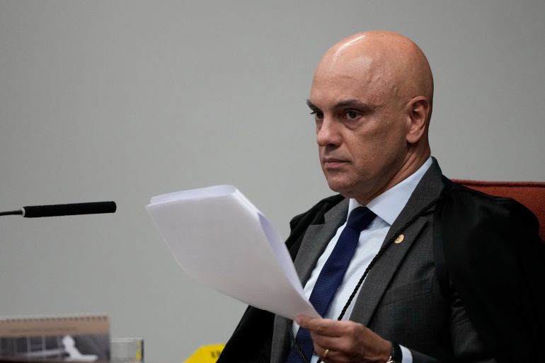 ap_6a6695f8191b1-1785107960 Justice Alexandre de Moraes reads his report during the trial of former Congressman Eduardo Bolsonaro at Brazil's Supreme Court in Brasilia, Tuesday, June 16, 2026. (AP Photo/Eraldo Peres)