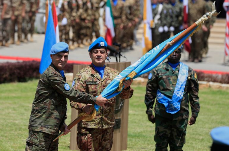 Former Head of Mission and Force Commander of the United Nations Interim Force in Lebanon (UNIFIL), Major General Aroldo Lazaro Saenz, of Spain, left, hands over the UN flag to the newly-appointed head of the mission Major General Diodato Abagnara, of Italy, during a ceremony to mark the transfer of authority at the UNIFIL headquarters in the southern Lebanese town of Naqoura, Lebanon, Tuesday, June 24, 2025. (AP Photo/Mohammed Zaatari)
