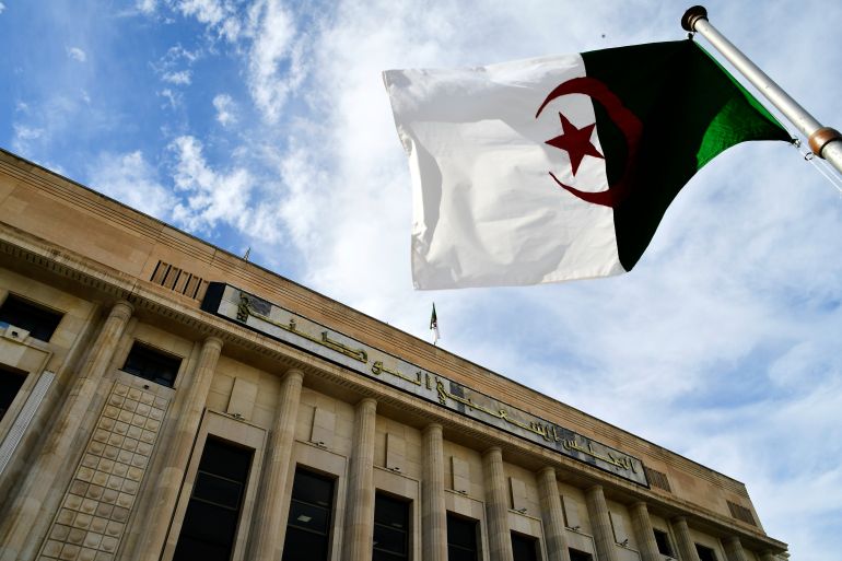 FILE -The Algerian flag flies outside the National Assembly as Parliament members vote on a bill seeking to criminalize France's colonisation, considering it a "state crime," and demanding that France issue an official apology and take legal responsibility for its colonial past in addition to compensations, Dec. 24, 2025 at her National Assembly in Algiers. (AP Photo/Fateh Guidoum, File)