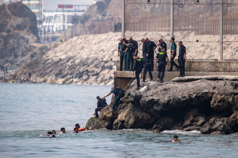 Migrants try to cross into the Spanish enclave of Ceuta from Morocco, Thursday, July 30, 2026. (AP Photo/Antonio Sempere)