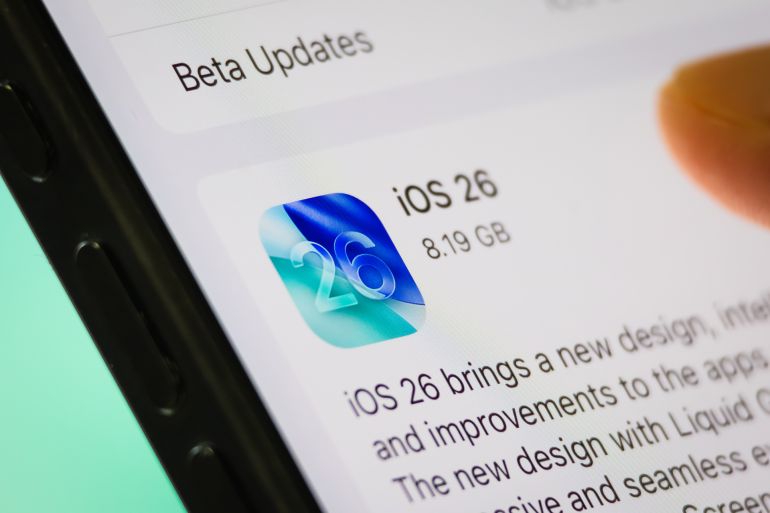d984d8a4d8a8d8a76-1758460668 CHONGQING, CHINA - SEPTEMBER 14: In this photo illustration, a smartphone screen shows the Apple iOS 26 update with a user's finger preparing to install it. iOS 26 introduces a new design, AI-powered features and improvements to system apps, as seen on September 14, 2025 in Chongqing, China. (Photo illustration by Cheng Xin/Getty Images)