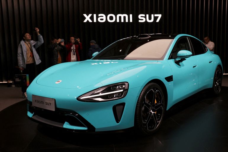 d9a2-1710336268 FILE PHOTO: Visitors film around Xiaomi's first electric vehicle, the SU7, displayed at an event in Beijing, China December 28, 2023. REUTERS/Florence Lo/File Photo