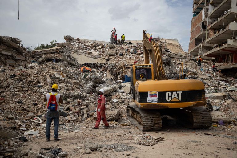 epa13089620 Rescue staff work at a building brought down by the double earthquake in Catia La Mar, Venezuela, 05 July 2026. Eleven days after the double earthquake struck the country, efforts are focused on clearing debris from collapsed buildings in La Guaira state, while search and rescue operations scale back. The two earthquakes of magnitude 7.2 and 7.5 struck Venezuela on 24 June 2026. EPA/Ronald Pena R