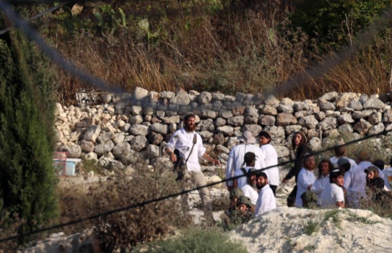 epa13132600 Israeli settlers, some armed, make their way at the West Bank village of Sara near Nablus, 25 July 2026. According to the Palestinian Red Crescent Society (PRCS), at least 30 Palestinians were wounded by tear gas from Israeli troops during clashes between Palestinians and settlers. EPA/ALAA BADARNEH