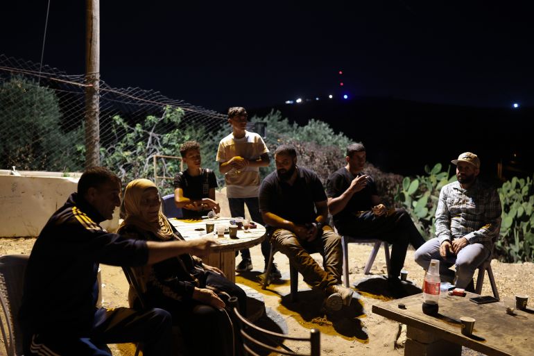 epa13136730 Palestinian Khadra Dar Khalil, 75, sits with other members of the Dar Khalil family as they guard their homes in an attempt to prevent settler attacks in the West Bank village of Sinjil, 27 July 2026 (issued 28 July 2026). The Israeli army imposed security restrictions and closures on Palestinians across the West Bank following clashes between Palestinians and Israeli settlers on 24 July in the village of Tell near Nablus, where four Palestinians and two Israeli security personnel were killed. EPA/ATEF SAFADI