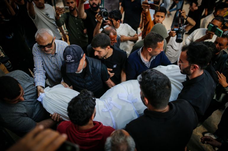 gaza4-1778933499 شيّع مئات الفلسطينيين في قطاع غزة، السبت، جثامين 8 أشخاص قُتلوا بقصف إسرائيلي استهدف، الجمعة، بناية سكنية مأهولة ومركبة مدنية في مدينة غزة، ضمن الخروقات اليومية لاتفاق وقف إطلاق النار الساري منذ 10 أكتوبر/ تشرين الأول 2025. ووفق مراسل الأناضول، فإن مراسم التشييع انطلقت من مستشفى الشفاء غرب مدينة غزة، حيث حمل المشيعون الجثامين على أكتافهم، وسط هتافات غاضبة تُندد باستمرار الخروقات الإسرائيلية واستهداف المدنيين. ( Saeed M. M. T. Jaras - وكالة الأناضول )