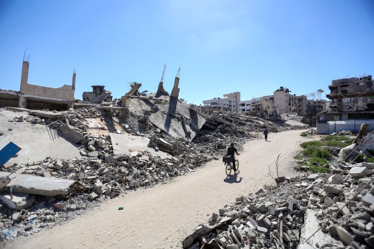 getty_6a4e17b265-1783502770 GAZA CITY, GAZA - JULY 2: Palestinians walk and cycle past buildings destroyed by Israeli airstrikes on July 2, 2026 in Gaza City, Gaza. One thousand days have passed since the Oct. 7, 2023 Hamas-led attacks on southern Israel that sparked a brutal campaign of retribution across the Gaza Strip. A ceasefire was agreed to between Israel and Hamas last October, but Israel has continued periodic bombing in the territory. (Photo by Ahmad Hasaballah/Getty Images)