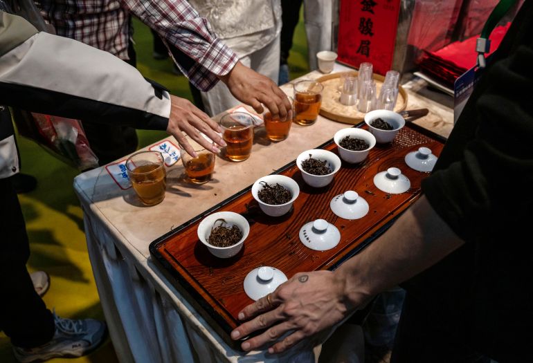 getty_6a6af8e537-1785395429 BEIJING, CHINA - APRIL 20: People reach to taste fine red tea at the 20th Beijing International Tea and Tea Ceremony Exhibition on April 20, 2026 in Beijing, China. While coffee has steadily grown in popularity in recent years, especially with young people, tea is still the drink of choice for the majority of Chinese people. Tea has been harvested, consumed and traded in China for thousands of years and is an integral part of Chinese culture. (Photo by Kevin Frayer/Getty Images)