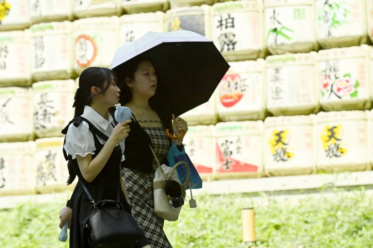 gettyimages-2285404881-1784029749 TOKYO, JAPAN - JULY 14 : A visitor uses a parasol while walking past a display of traditional votive plaques at the Meiji Jingu shrine during hot weather in Tokyo, Japan, July 14, 2026. Authorities advised people to avoid prolonged exposure to the sun and drink fluids frequently. (Photo by David Mareuil/Anadolu via Getty Images)