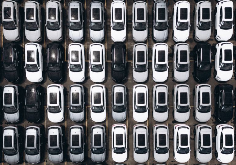 m-1785408215 Aerial shot of a parking lot with rows of parked cars in Brazil, showcasing organization and modernity.