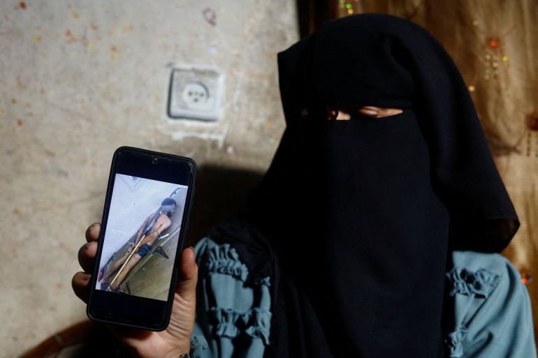 reuters_6a49649f-1783194783 Rana Abu Nassar, mother of Palestinian prisoner Osama Abu Nassar who is held by Israel, holds a mobile phone displaying a widely circulated image that she believes shows her son restrained while in Israeli custody, at her home in Al-Maghazi refugee camp, central Gaza Strip, July 3, 2026. The image has sparked a desperate search for the man's identity, with two Palestinian families claiming him as their son. REUTERS/Mahmoud Issa