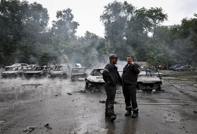 reuters_6a499674-1783207540 Workers stand near charred vehicles at the parking hit by a Russian air strike, amid Russia's attack on Ukraine, in Zaporizhzhia, Ukraine July 4, 2026. REUTERS/Stringer
