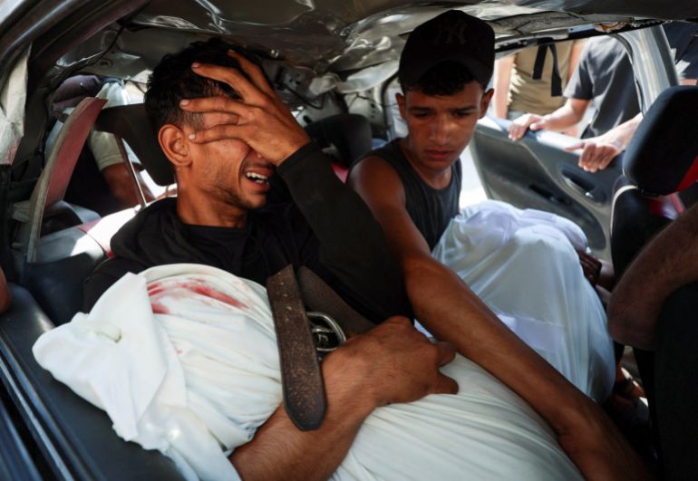 reuters_6a5a1ff4-1784291316 Palestinian man, Hamas Al-Hdabi, mourns holding the body of his father, Sohail, who was killed in an Israeli strike, as Hamas sits inside a car during the funeral, in Gaza City, July 16, 2026. REUTERS/Dawoud Abu Alkas