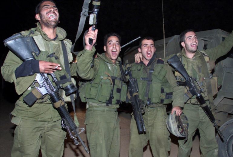 reuters_6a5a55bb-1784305083 FILE PHOTO: Israeli infantry soldiers cheer and sing as they lift their weapons after they crossed from southern Lebanon back into Israel as part of the Israeli withdrawal from southern Lebanon, in northern Israel, May 23, 2000. The apparent acceleration of the troop withdrawal, ending 22 years of occupation of southern Lebanon. REUTERS/Jim Hollander/File Photo
