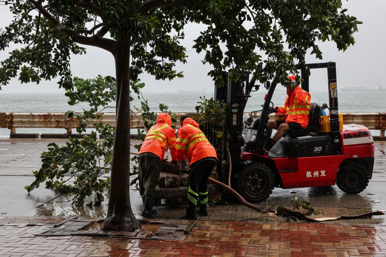 reuters_6a65a8ce-1785047246 Workers clear fallen debris and obstacles from the road after Typhoon Noul, in Hong Kong, China, July 26, 2026. REUTERS/Tyrone Siu