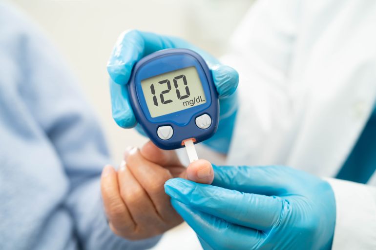 السكري - Doctor use digital glucose monitor measure and test stripe for check diabetes from finger blood sugar level.