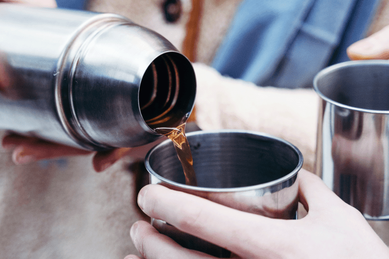 10-1786040082 شخص يشرب القهوة في وعاء من الاستنالس استيل A person drinks coffee in a stainless steel pot