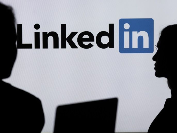 10a715a6-3e4e-4a1a-a433-0929e8b31f1e Digital Applications- - ANKARA, TURKEY - JULY 18 : Silhouettes of a people are seen in front of the logo of social networking application LinkedIn in Ankara, Turkey on July 18, 2018.