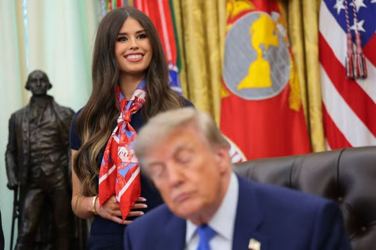 WASHINGTON, DC - AUGUST 10: Jayme Leagh Franklin with The Conservateur (L), stands behind U.S. President Donald Trump (R), before he signs an executive order calling for childhood vaccine shots to be spaced out into separate visits during an event in the Oval Office of the White House on August 10, 2026 in Washington, DC. During his second term, Trump has urged Health and Human Services Secretary Robert F. Kennedy Jr. to investigate further research on vaccines. (Photo by Anna Moneymaker/Getty Images)