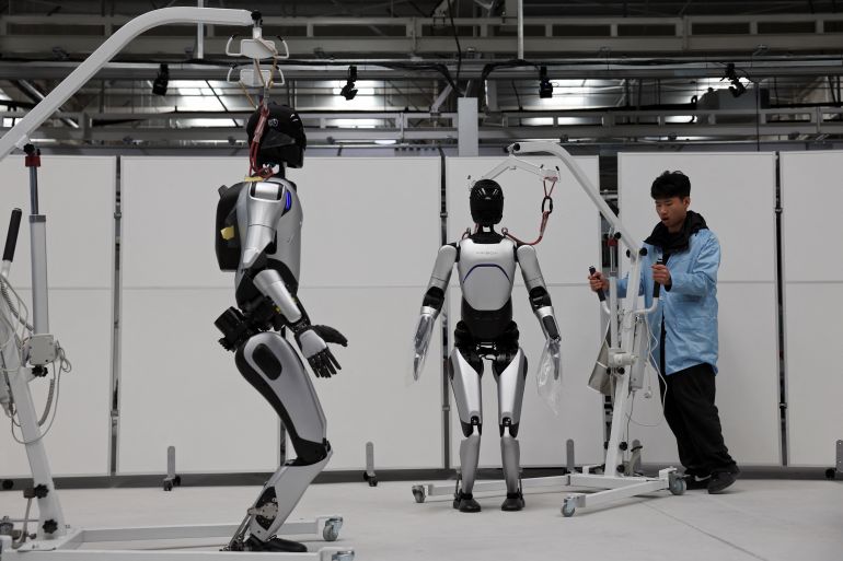 202bots-1759136166 A humanoid robot walks as employees conduct tests on the robots, on the production line at the AgiBot factory in Shanghai, China March 20, 2025. REUTERS/Florence Lo