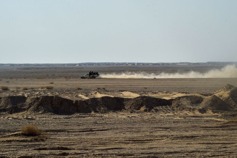 2nimruz-desert-1785656436 In this picture taken on February 17, 2022, Afghan migrants ride in a pickup truck along a desert road toward the Afghanistan-Iran border in Nimruz. In Zaranj, a border town in southwestern Afghanistan, people smugglers say the flow of would-be exiles now reaches 5,000 to 6,000 a day -- four times more than before the Taliban's return to power in August. (Photo by Wakil KOHSAR / AFP) / TO GO WITH AFGHANISTAN-PAKISTAN-IRAN-MIGRATION BY ROMAIN FONSEGRIVES AND QUBAD WALI