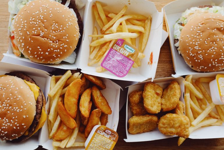 4021926-1786618597 Top view of an assorted fast food meal including burgers, fries, and nuggets.
