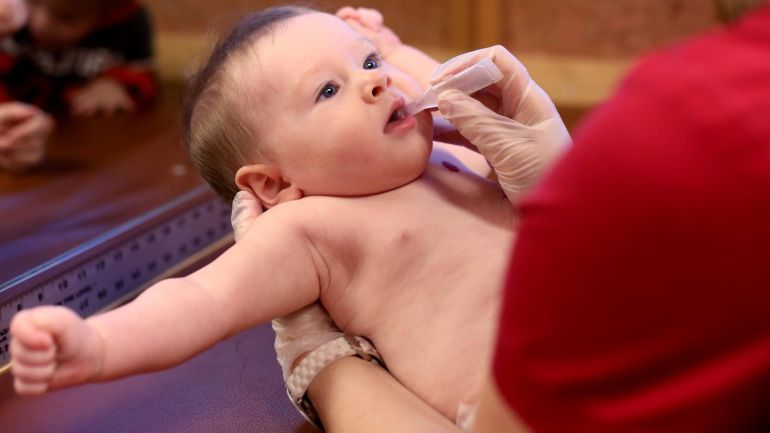 FILE - In this Feb. 12, 2015, file photo, an oral vaccine is given to 6-month-old James Noland at Childhood Health Associates in Salem, Ore. The Oregon Senate Committee on Education is scheduled to vote on a bill requiring all schools to make public the rate of students opting out of one or more immunizations - a measure drawing angry feedback from parents who feel it publicly shames families who decide to forego some shots, while others say it is merely another attempt by legislators to take away their parental rights and require mandatory vaccinations. (AP Photo/Statesman Journal, Anna Reed, File)