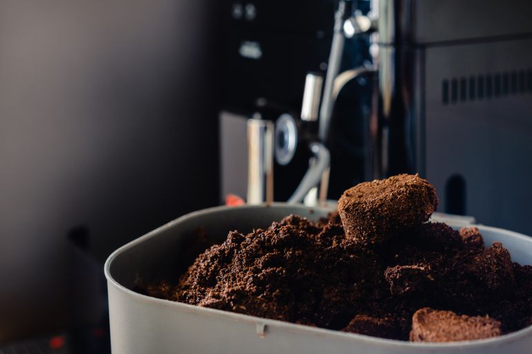 Used coffee grounds from espresso machine. Recycling compost container filled with used coffee waste. Coffee machine cleaning. المصدر: أدوبي ستوك
