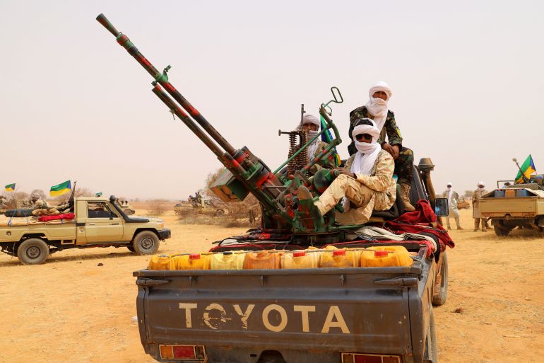 afp-7788773-1786983532 An anti aircraft gun is seen mounted on the back of a pick up truck as militants from the Movement for the Salvation of Azawad (MSA), a Tuareg political and armed movement in the Azawad Region in Mali, gather in the desert outside Menaka on March 14, 2020 during the MSA congress. (Photo by Souleymane Ag Anara / AFP)