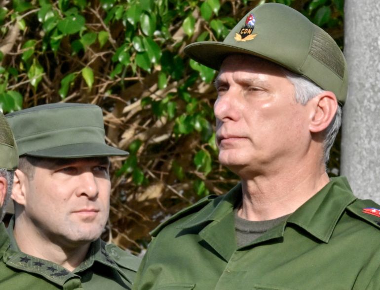 Cuba's President Miguel Diaz-Canel (R) and Cuba's Colonel Raul Guillermo Rodriguez Castro, grandson of former President Raul Castro, attend the funeral of the 32 Cuban soldiers killed during the US incursion in Venezuela at Colon cemetery in Havana on January 16, 2026.