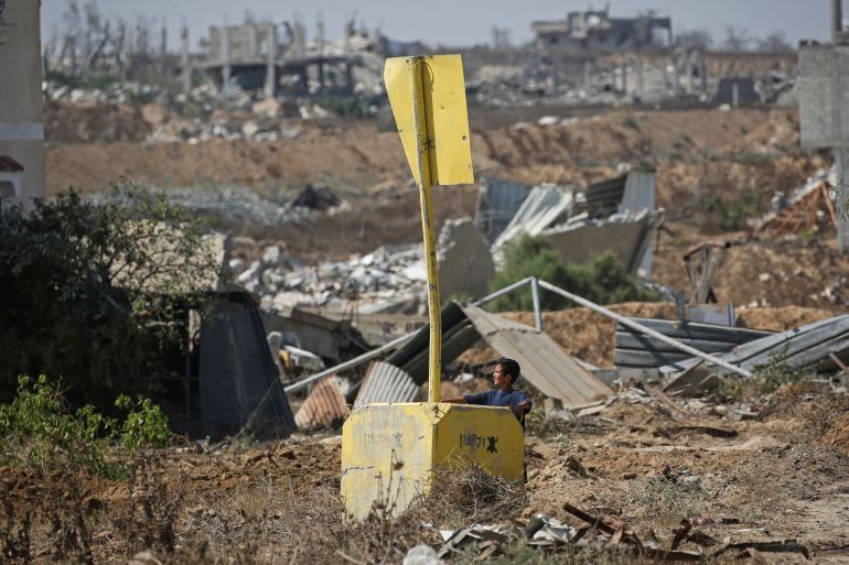 afp_6a6124563a5c-1784751190 A Palestinian boy stands under a concrete block marking the 'Yellow Line' drawn by the Israeli military in the east of Deir al-Balah, central Gaza Strip on July 22, 2026, as violence has continued in Gaza despite the ceasefire.