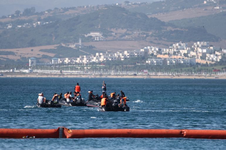afp_6a6f3176a81b-1785672054 People aboard inflatable boats navigate on the Moroccan side of the new floating barrier deployed by Spain to reinforce security near the border post of the Spanish enclave of Ceuta on August 2, 2026.