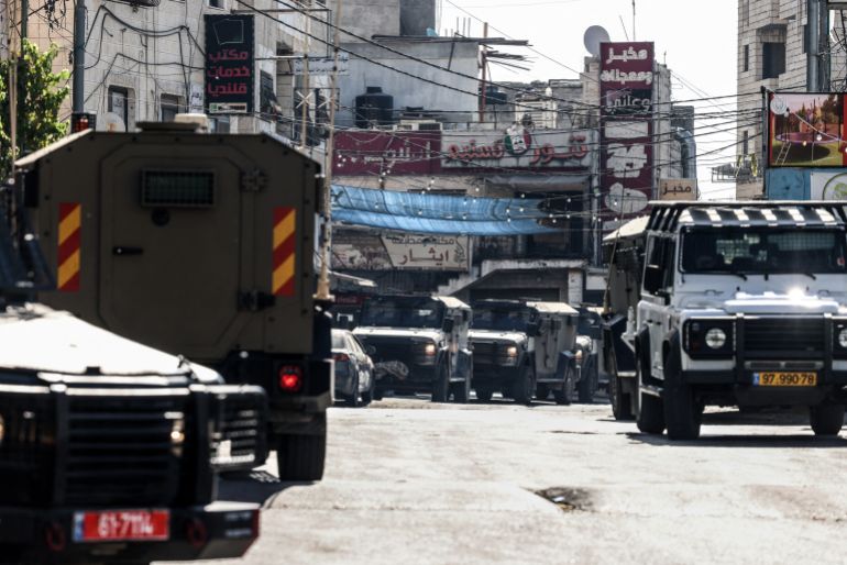 afp_6a742a66780b-1785997926 Israeli security forces vehicles are seen deployed on a street during a military raid in the Qalandia refugee camp, south of Ramallah in the Israeli-occupied West Bank, on August 5, 2026.