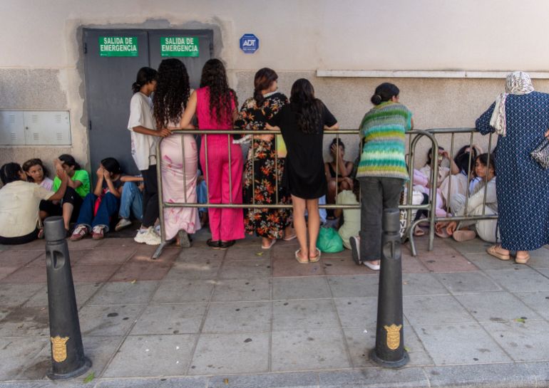 Migrant minors wait outside the National Police headquarters to begin identification and registration procedures in the Spanish North African enclave of Ceuta on August 7, 2026, following a mass influx of migrants from Morocco in recent days.