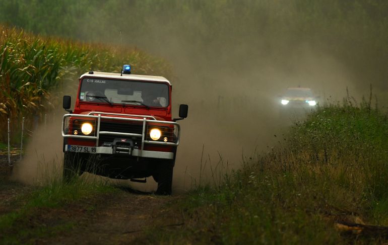 afp_6a831aac0cd5-1786976940 This photograph shows a fire truck driving in the forest of Luglon, south-western France on August 14, 2026. (Photo by Gaizka IROZ / AFP)