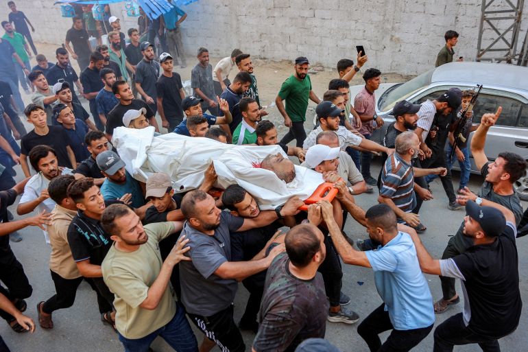 afp_6a85f372591f-1787163506 EDITORS NOTE: Graphic content / Mourners march with the body of Palestinian police officer Ayman Jundiya during his funeral procession, after he was killed in an Israeli strike on the municipal police headquarters in Gaza City, in Gaza City on August 19, 2026.