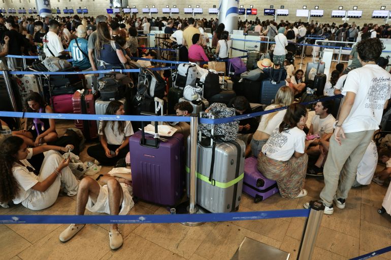 afp_6a8835ac2ed7-1787311532 Passengers wait with their luggage at a check-in area amid disruptions caused by a surprise staff strike at Ben Gurion Airport in Lod, near Tel Aviv, on August 20, 2026.