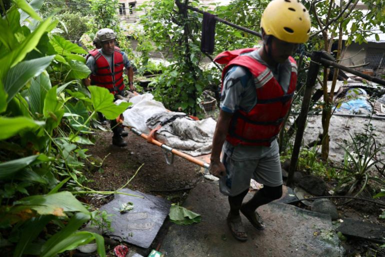 afp_6a8fd28d13e7-1787810445 Rescue personnel carry the body of a victim who died after flash floods near Devighat, Bidur Municipality in Nepal's Nuwakot district on August 27, 2026.