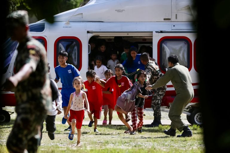 Rescued children disembark from a helicopter at an army camp following flash floods, in Battar Bazar town in Nepal's Nuwakot district on August 28, 2026.