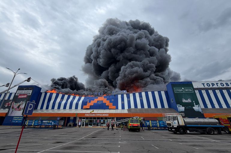 afp_6a91e8e3ca9e-1787947235 Ukrainian rescue personnel work to extinguish a fire in a damaged shopping mall following an air attack in Zaporizhzhia on August 28, 2026, amid the Russian invasion of Ukraine.