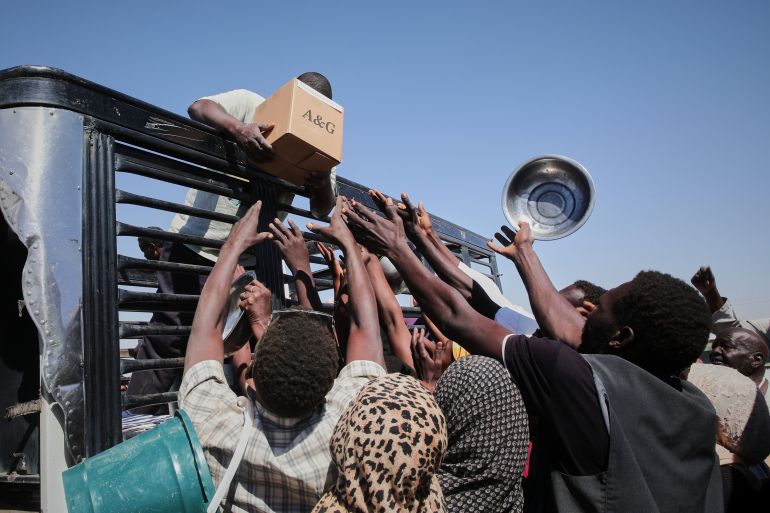 ap_6a47cc274eb33-1783090215 FILE.- Sudanese families displaced from El-Fasher reach out as aid workers distribute food supplies at the newly established El-Afadh camp in Al Dabbah, in Sudan's Northern State, Nov. 16, 2025. (AP Photo/Marwan Ali,File)