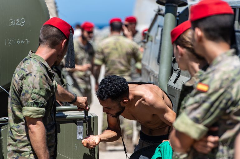 ap_6a6f767114b72-1785689713 A migrant who crossed into Spain from Morocco drinks water distributed by Spanish soldiers in the Spanish enclave of Ceuta, Sunday, Aug. 2, 2026. (AP Photo/Antonio Sempere)